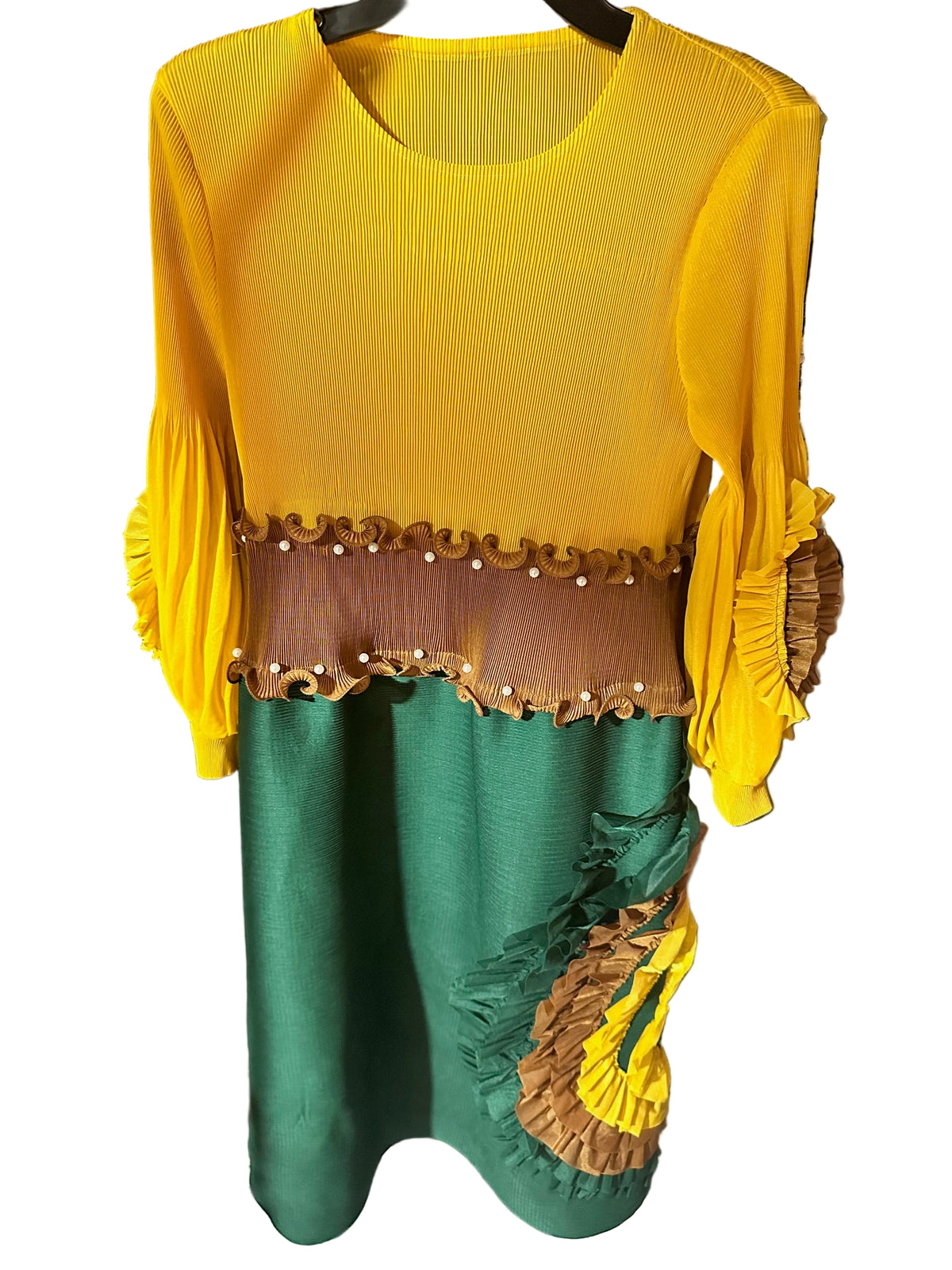 Yellow and green top with decorative trim on a black surface.