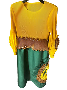 Yellow and green top with decorative trim on a black surface.
