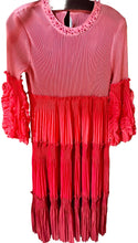 Load image into Gallery viewer, Pink dress with ruffled details on a hanger against a patterned wall.